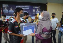 Hj,Masnah Busyro,SE Menyerahkan Tropi Kepada Para Juara Turnamen Game Legedaris Bupati Cup Milenial 2022